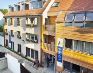 Die Fassade teilt sich in einen mit Lärchenholz verkleideten und einen verputzen Teil