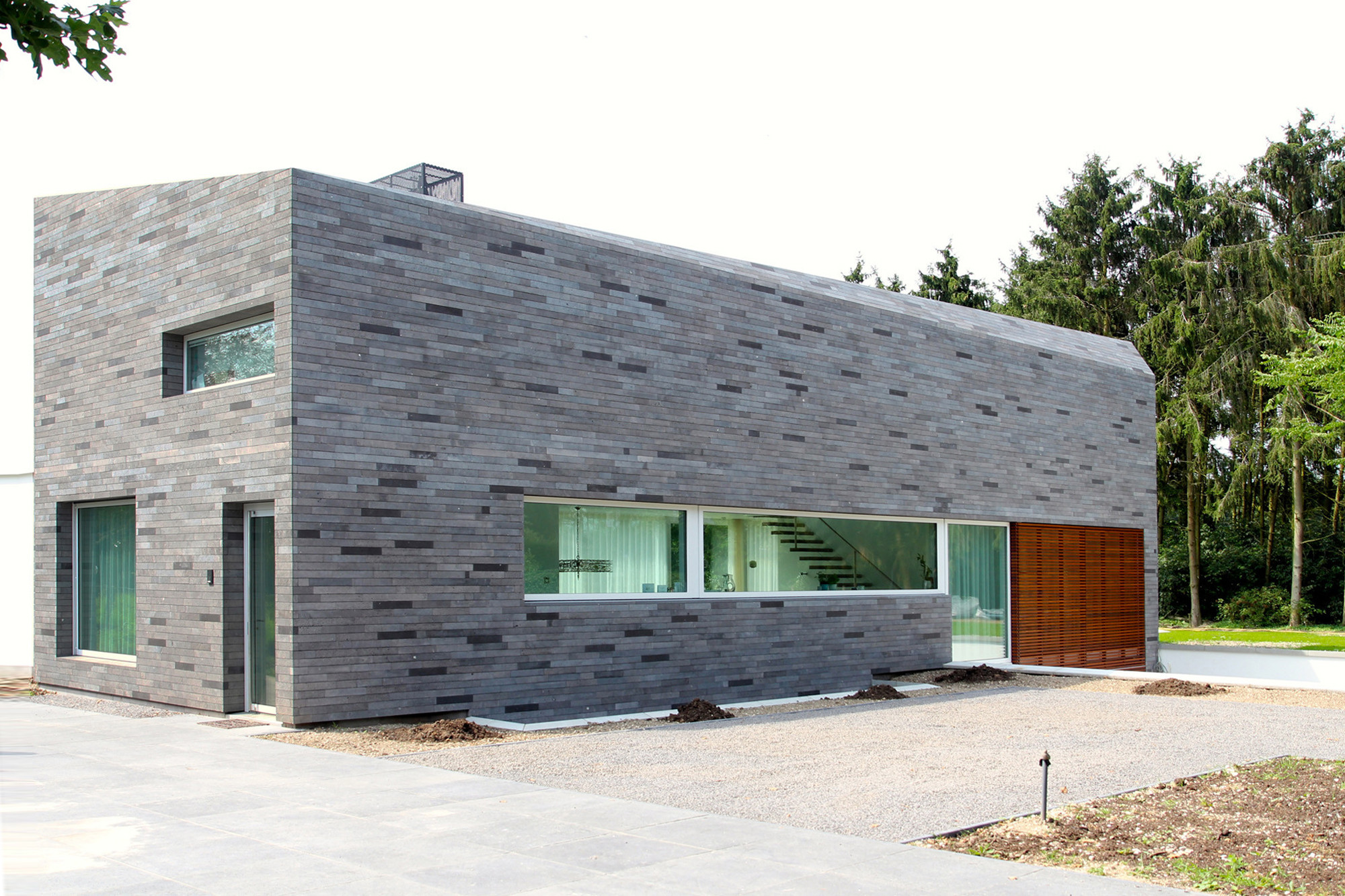 Die Basaltlavaverblender an Fassade und Dach unterstreichen den monolithischen Charakter des Gebäudes