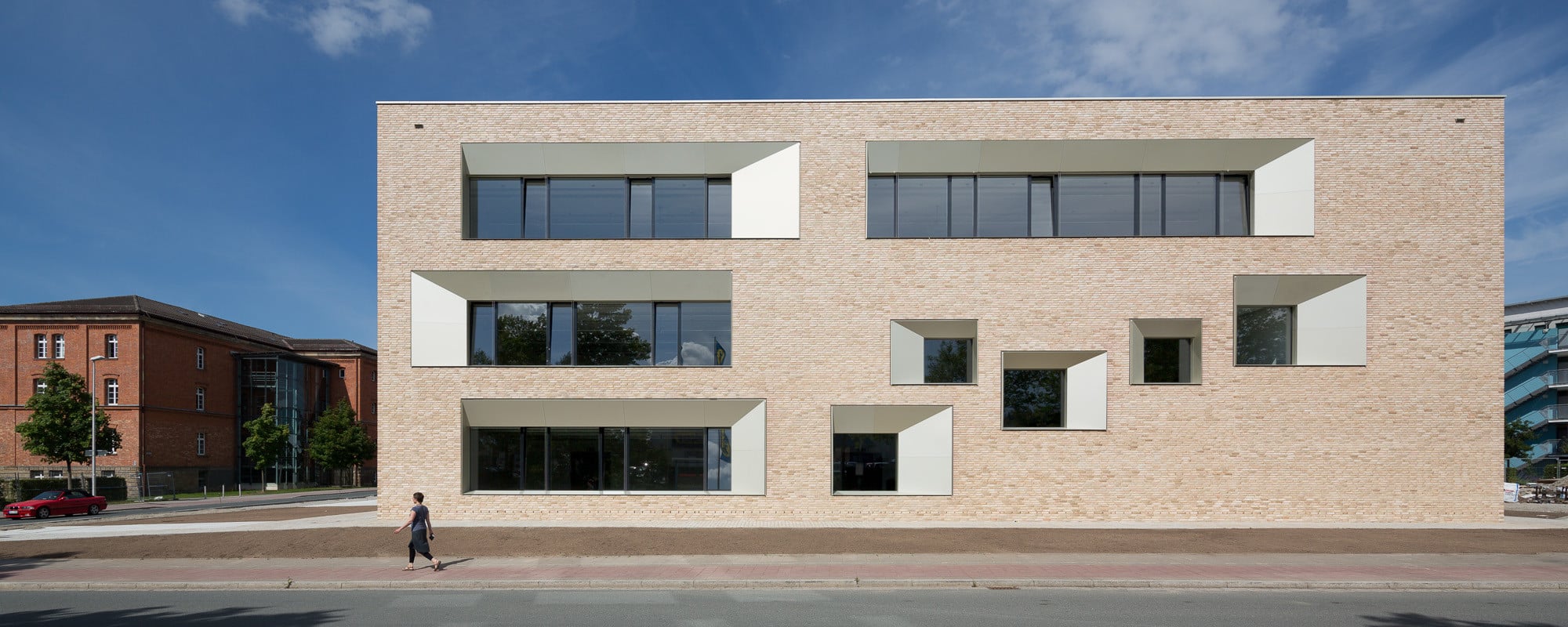 Ostfassade: Die Loch- und Bandfenster weisen oben und an einer Seite schräge Leibungsbleche auf, deren Maße variieren (hinter den diagonal angeordneten Fensteröffnungen befindet sich der Hörsaal)
