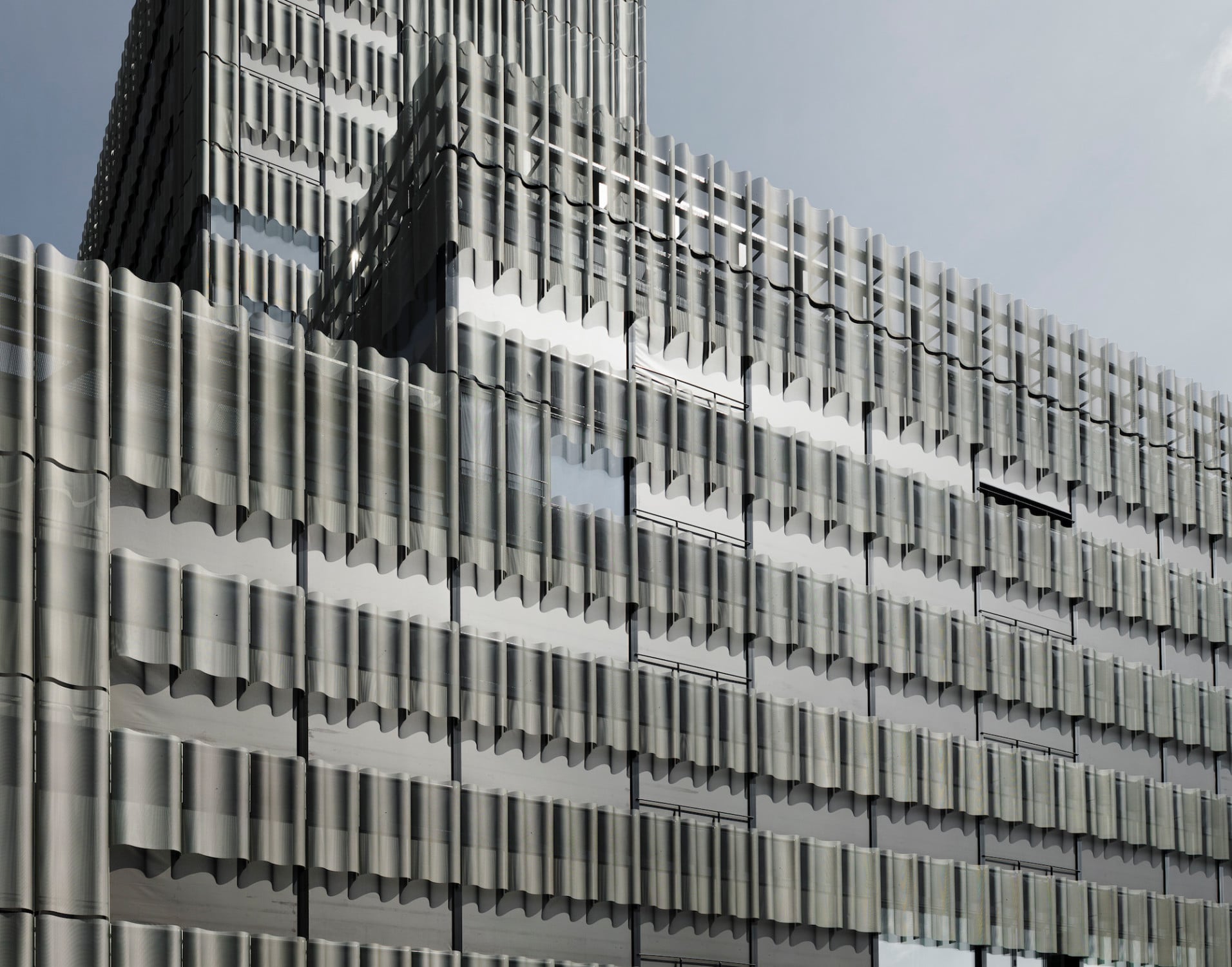 Die gewellte Streckmetallfassade wurde dem Bestand auf einer Metallunterkonstruktion vorgehängt