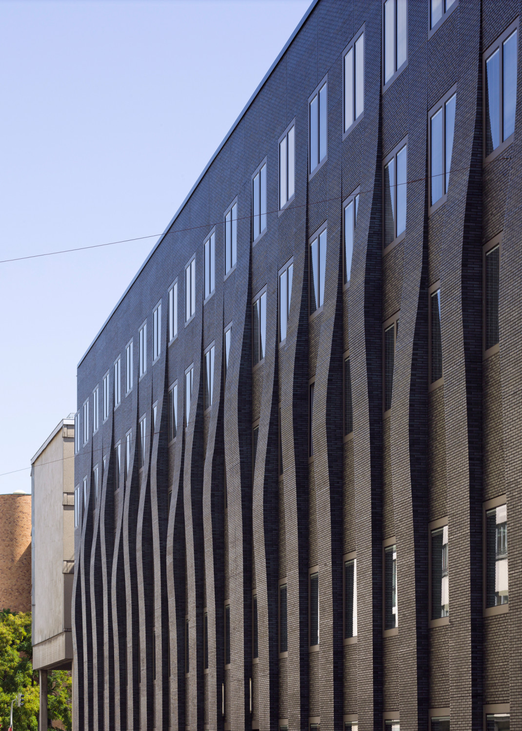 Unregelmäßige Wellenverläufe lassen die Fassade lebendig erscheinen
