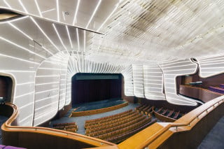 Der Theatersaal mit mattweiß leuchtender Unterdeckenkonstruktion