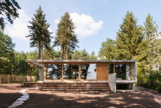 Die Südfassade öffnet sich mit einer Glasfront zum See und wird von dünnen Betonscheiben gerahmt