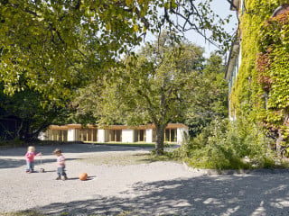 Neubau und eines der Bestandsgebäude des Kinderhauses Entlisberg in Zürich