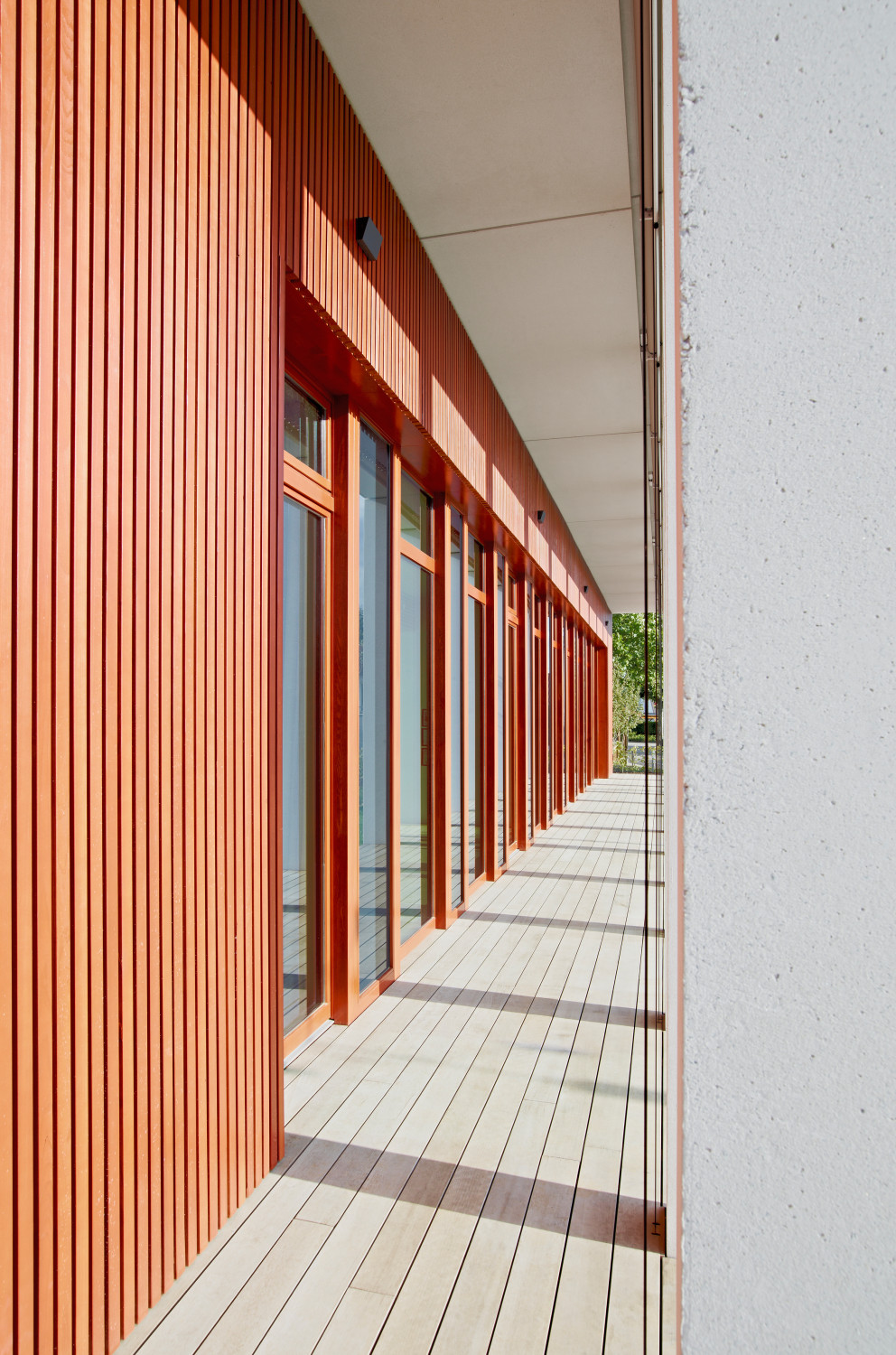 Vor den Gruppenräumen der Krippe bildet eine Pergola einen überdachter Außenbereich und dient zugleich als baulicher Sonnenschutz