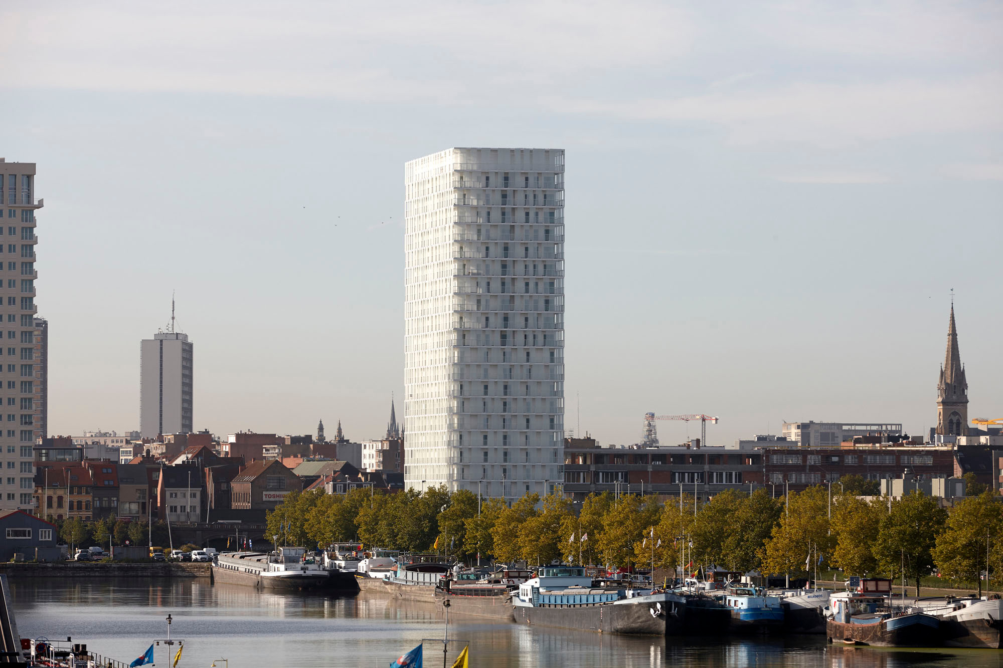 Geschossweise versetzte, unregelmäßig angeordnete Glaspaneele verleihen der Fassade Tiefenwirkung