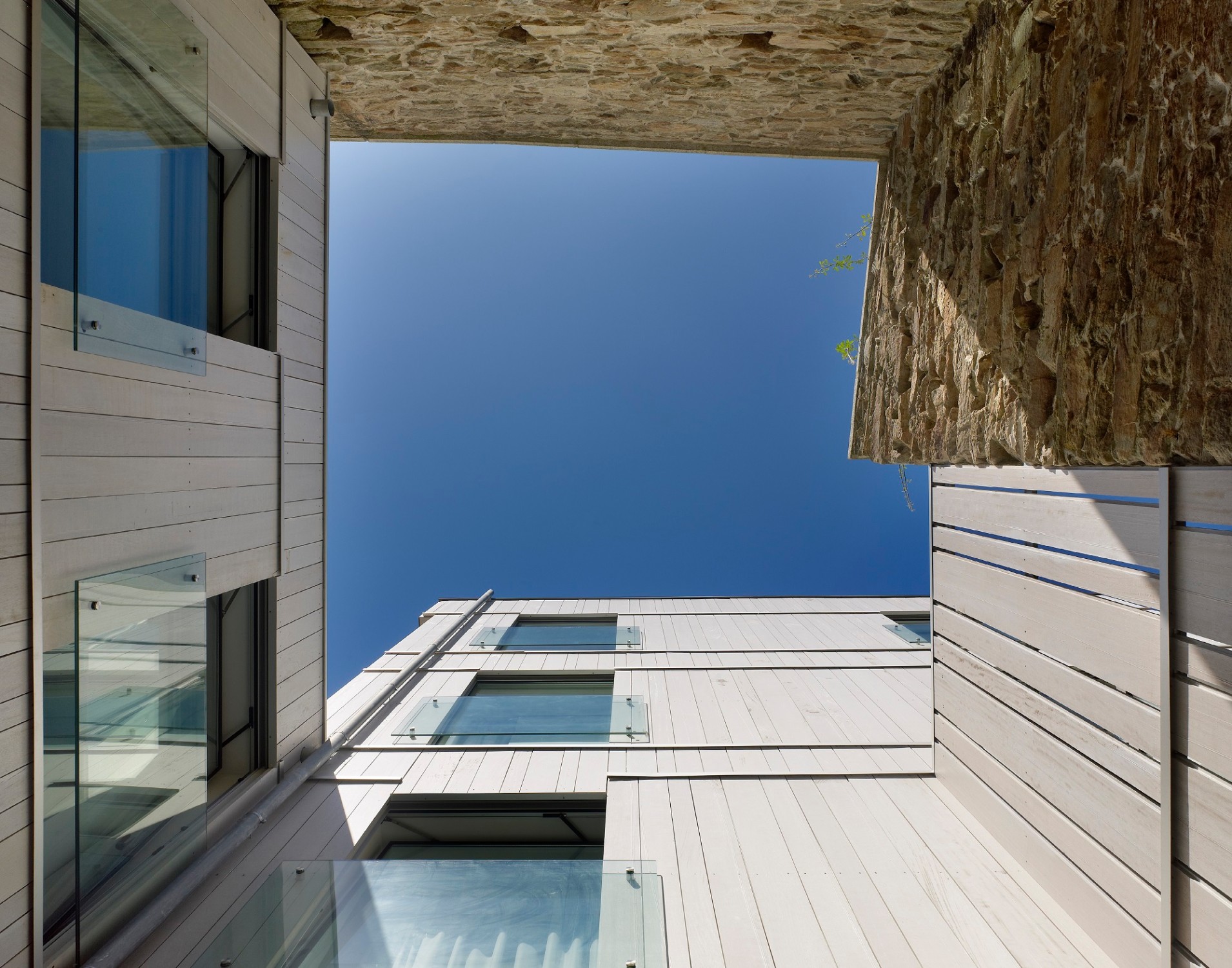 Patio: Die Holzfassade des Anbaus steht im Kontrast zu den massiven historischen Mauern