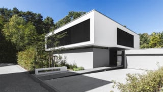 Ansicht Südost mit Eingang: Das Wohnhaus besteht aus zwei sich überlagernden, leicht zueinander verdrehten Baukörpern