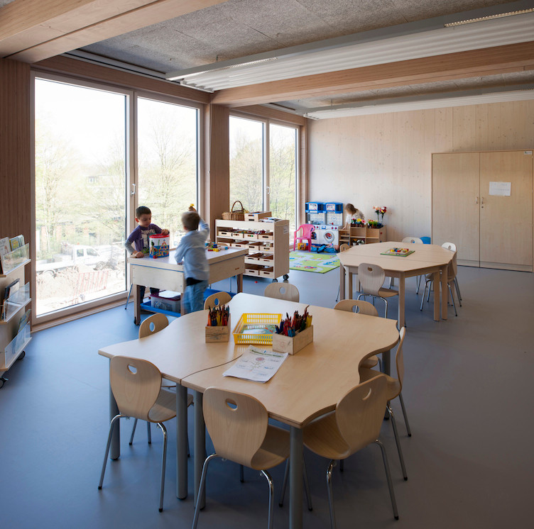 Jedes der 17 Klassenzimmer wird aus drei Modulen gebildet, von denen die beiden äußeren eine geschlossene Seitenwand aus Brettsperrholz haben; in Längsrichtung spannen Unterzüge aus Buche