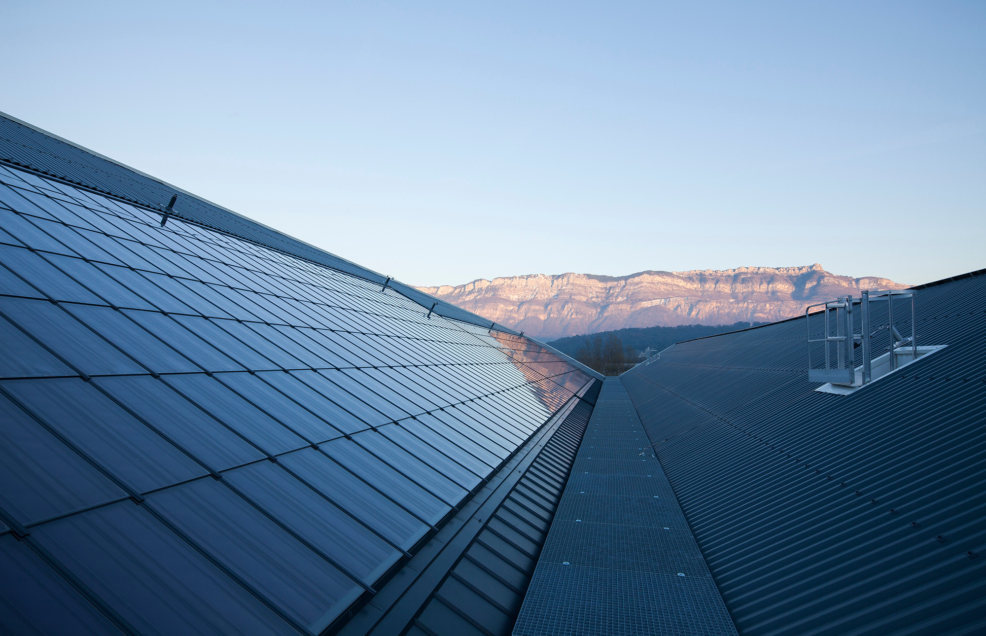 Auf dem Dach ragt ein riesiger gefalteter Flügel zum Einfangen des Sonnenlichts empor, der mit solarthermischen Kollektoren und Photovoltaikmodulen bestückt ist