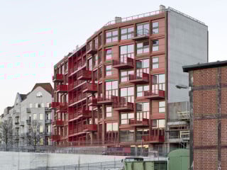 Die Häuser stehen auf einem Sockel entlang der neu angelegten Straße Am Lokdepot gegenüber von backsteinernen Lagerhallen