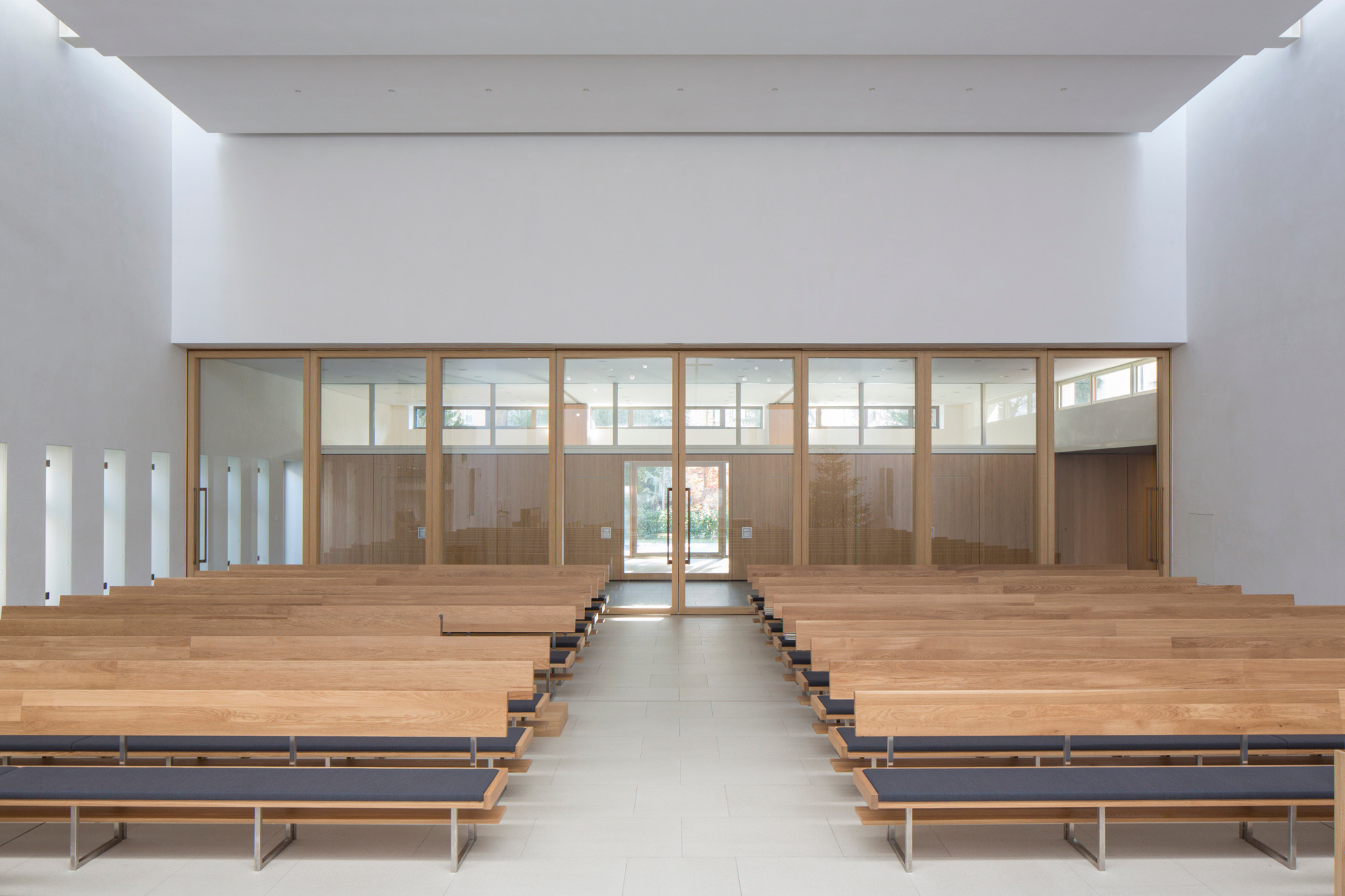 Die Akustikdecke streut den Schall und lenkt ihn in den Kirchenraum; ihre Materialität wirkt zudem leicht schallabsorbierend