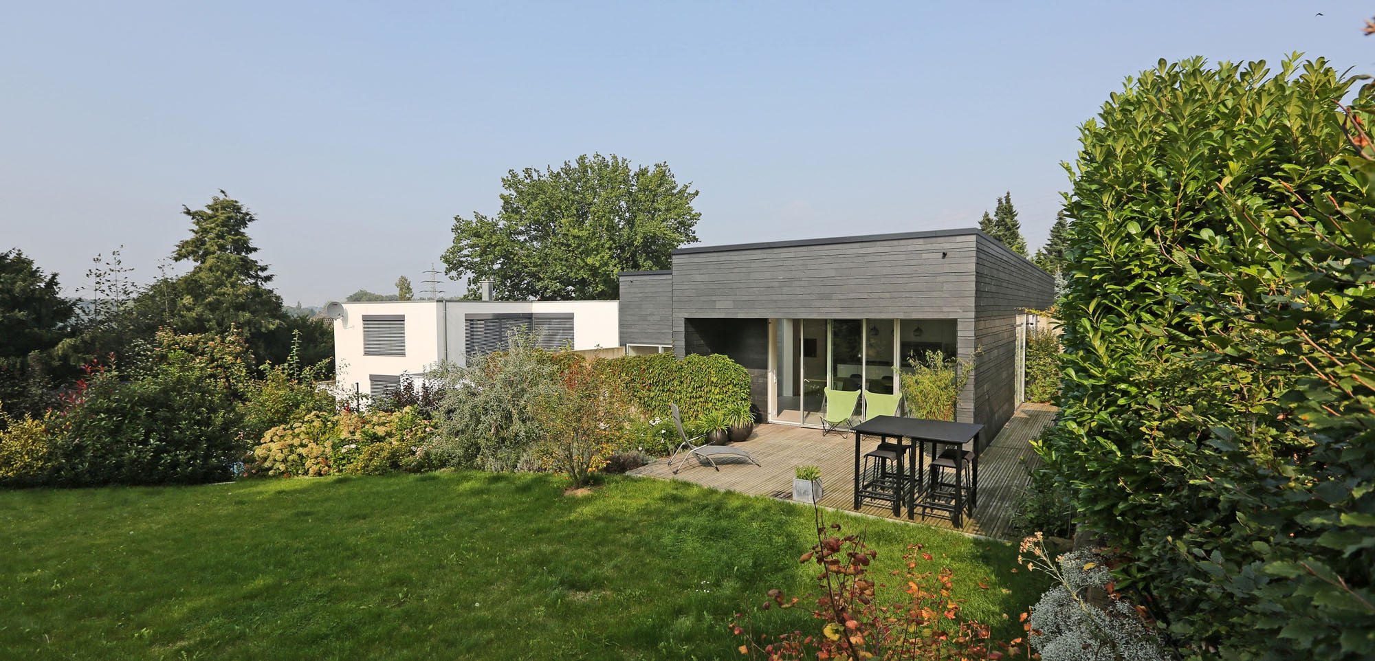 Ansicht Gartenseite von Südwesten: Der Essraum öffnet sich über große Verglasungen zur Terrasse