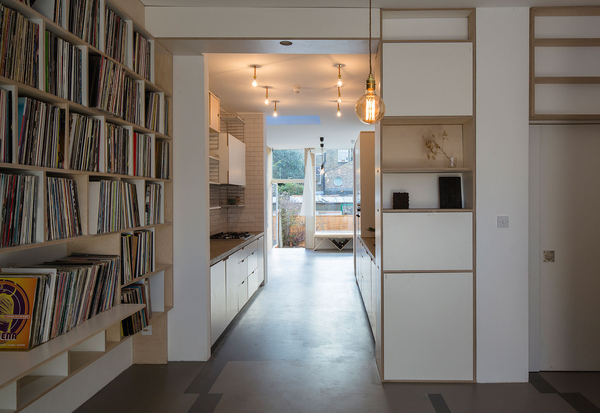 Blick vom Wohnraum mit den neuen Einbaumöbeln durch die Küche und Essraum bis in den Garten; rechts angeschnitten im Bild der Windfang mit Garderobe 