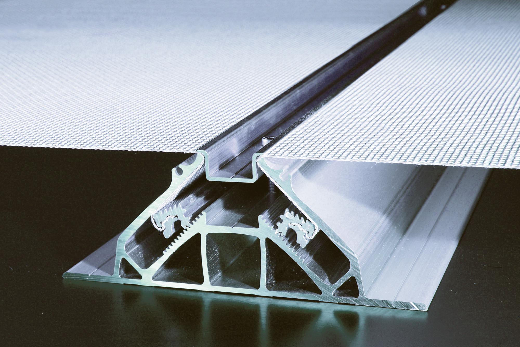 Das Spannsystem mit verdeckten Aluminiumprofilen kann als vorgehängte hinterlüftete Fassade, als integrierter Sonnenschutz oder als zusätzliche Fassadenebene für besondere Effekte verwendet werden
