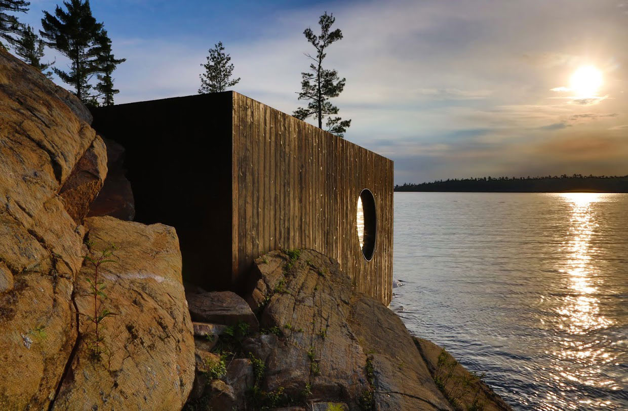 Die hölzerne Box ist direkt am Wasser in die kaskadenförmig abfallende Felsformation aus Granit platziert, ein Teil von ihr ragt über die Felsen hinaus