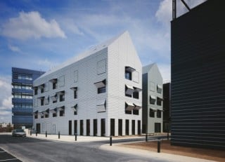 Die Architekten planten ein Ensemble aus zehn Häusern, die in zwei Fünfergruppen einander gegenüberstehen und eine mittig liegende Zufahrtsachse fassen (Nordwestansicht des östlichen Häuserensembles und Zufahrt)