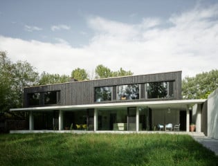 Von Süden: Zum Garten richtet sich das zweigeschossige Wohnhaus mit großen Verglasungen