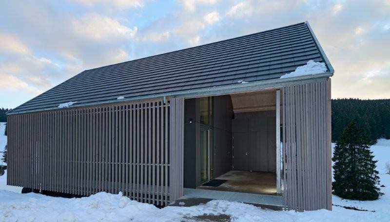 Bestimmend für die Erscheinung des Hauses ist seine Hülle aus einem senkrechten Stabwerk aus Weißtanne