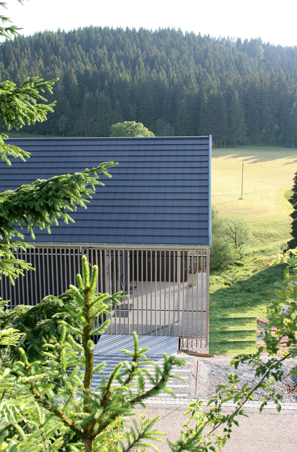 Das Eingangsgeschoss mit integrierten Parkplatz wird bergseitig erschlossen