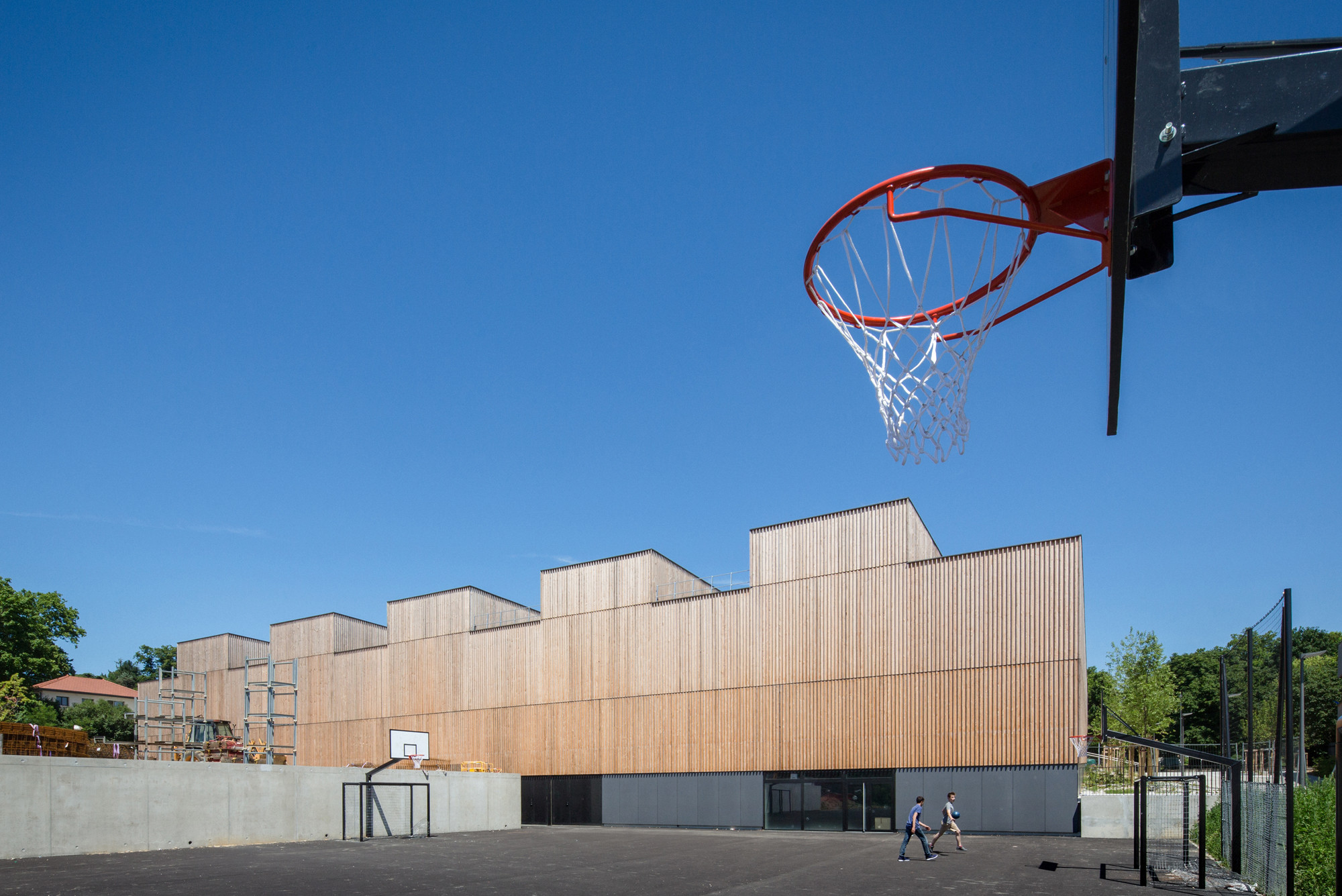 Auf der Rückseite ist die Sporthalle in ihrer ganzen Höhe von neun bzw. zwölf Metern Höhe sichtbar 