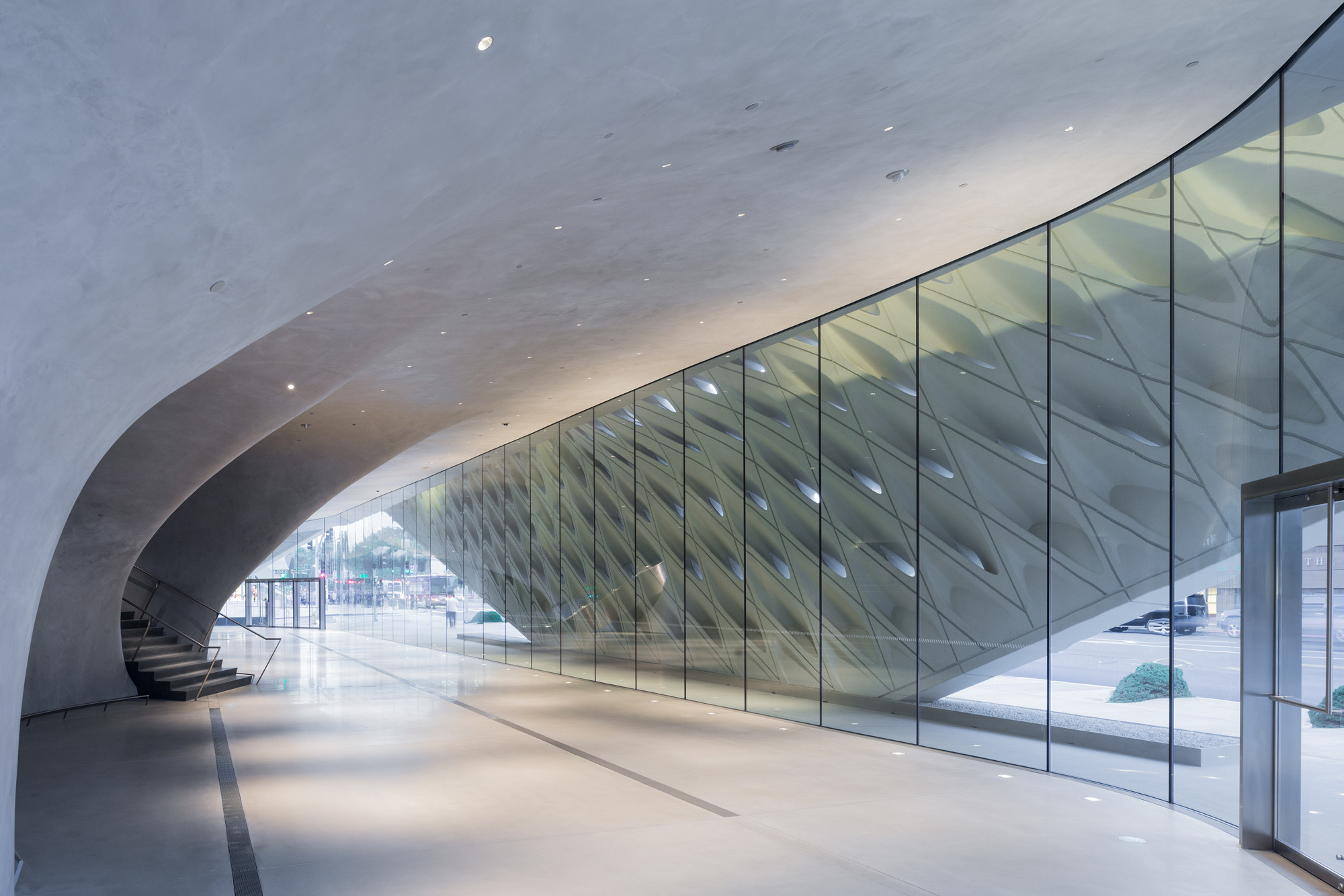 Ein Tageslicht filternder Betonschleier ist dem Gebäude übergeworfen und eine Höhle nimmt das Depot auf