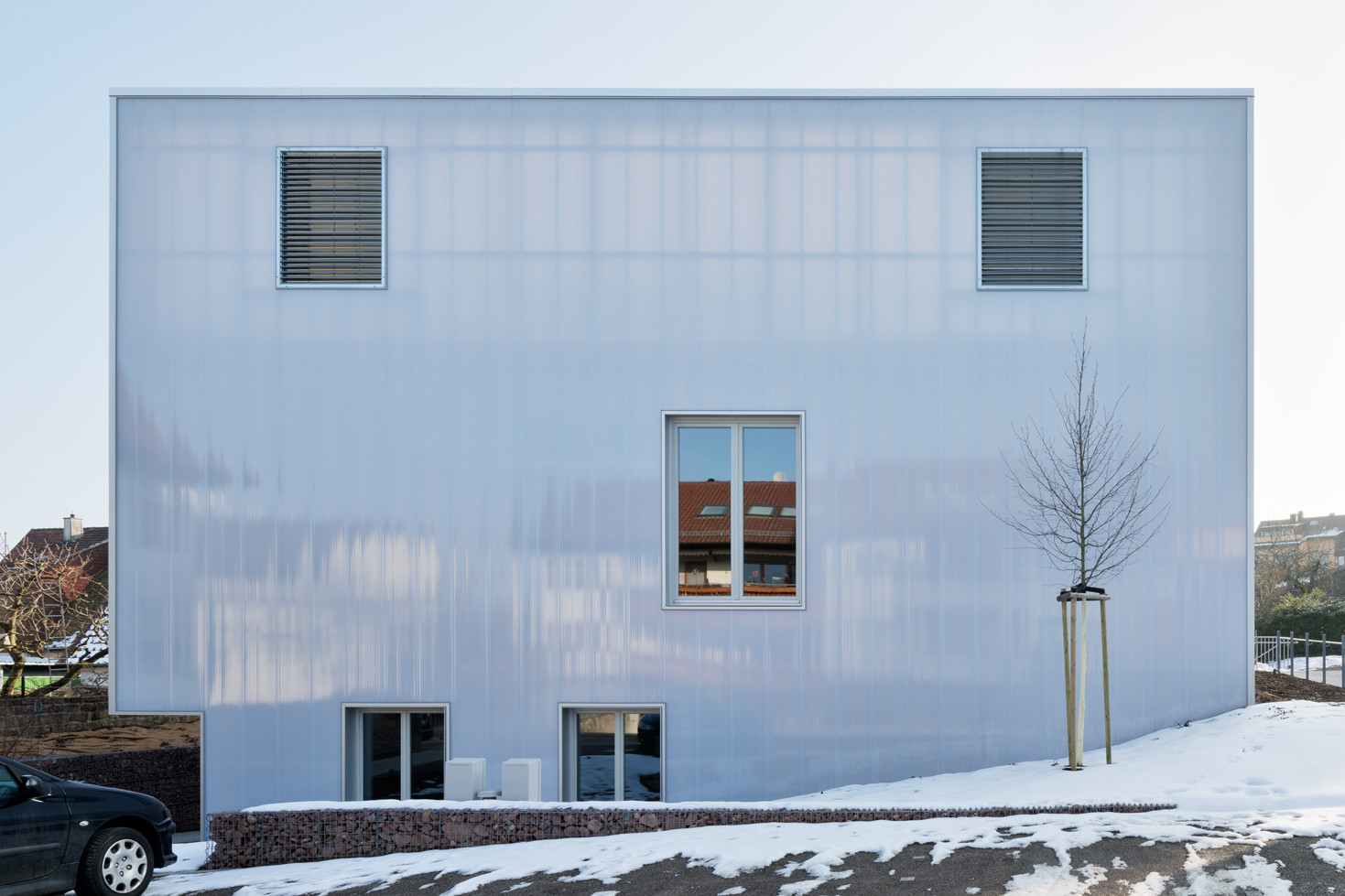 Die transluzente Fassadenhülle aus Polycarbonat legt sich homogen um den gesamten Baukörper