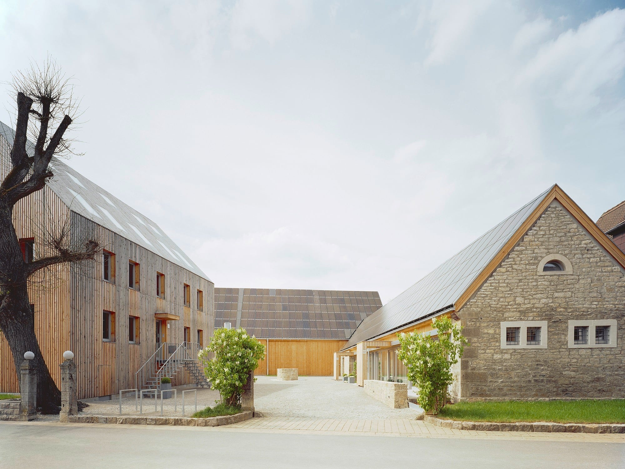 Hauptzugang von Südosten: Links das ehemalige Bauernhaus, rechts die alte Remise, die nun Seniorenwohnungen beinhaltet
