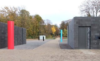 Eine Rauminstallation aus farbigen Stahlsäulen des Bildhauers Erich Reusch durchbricht die geraden Sichtachsen im Bochumer Schlosspark, ohne zu dominieren