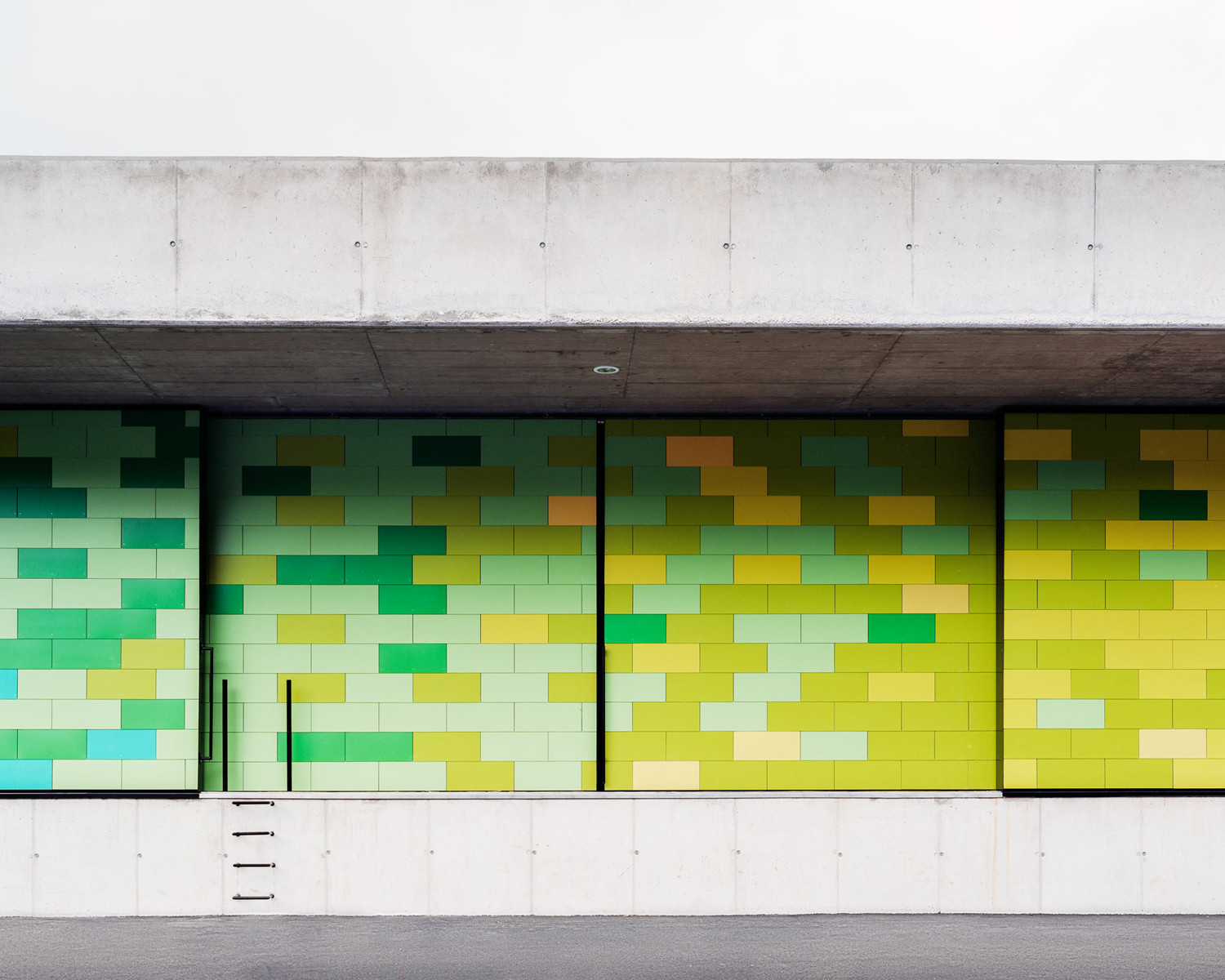 Bis auf wenige Öffnungen ist die Fassade geschlossen ausgebildet