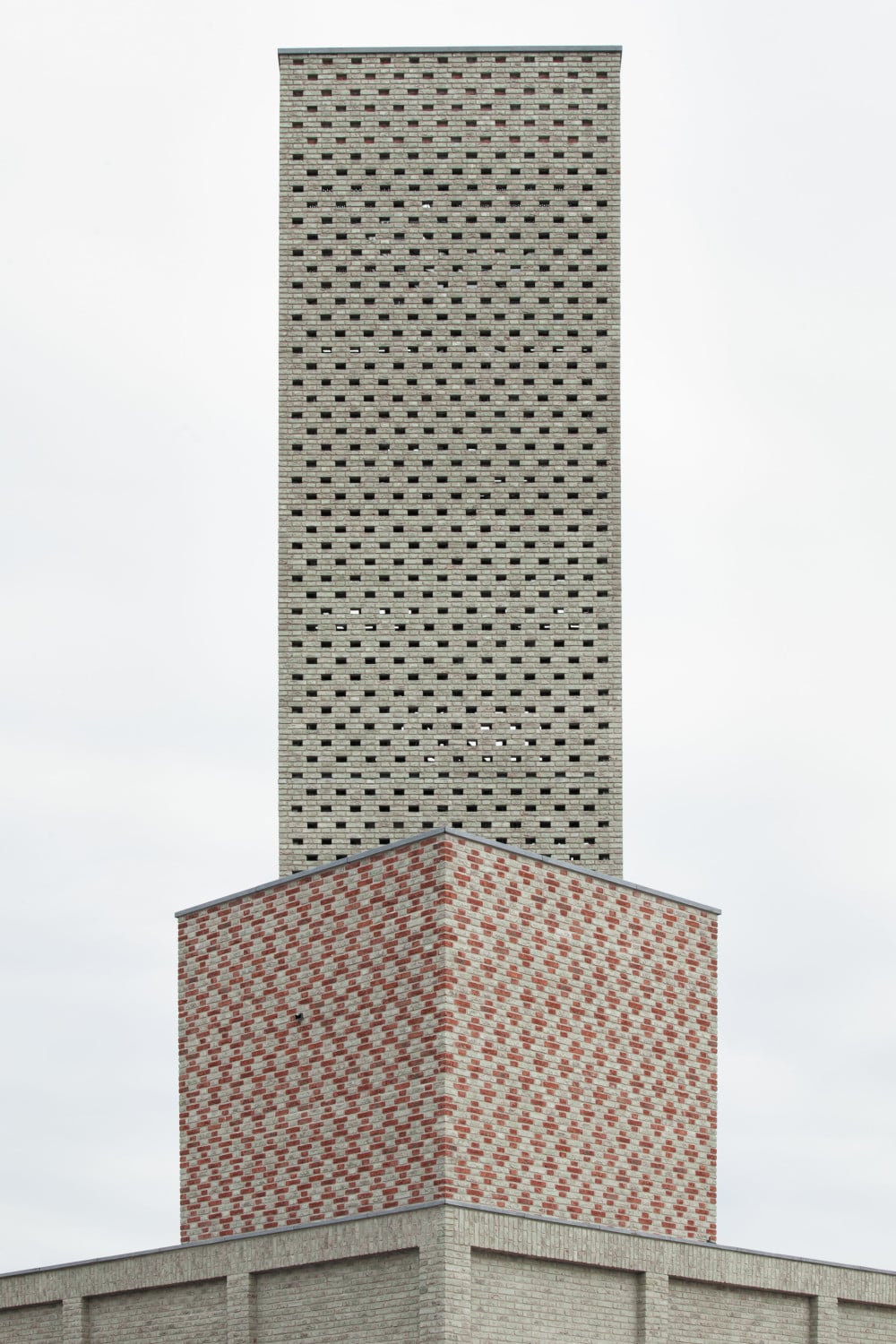 Auf dem Sockelbau steht ein um 45 Grad verdrehter hoher Turm
