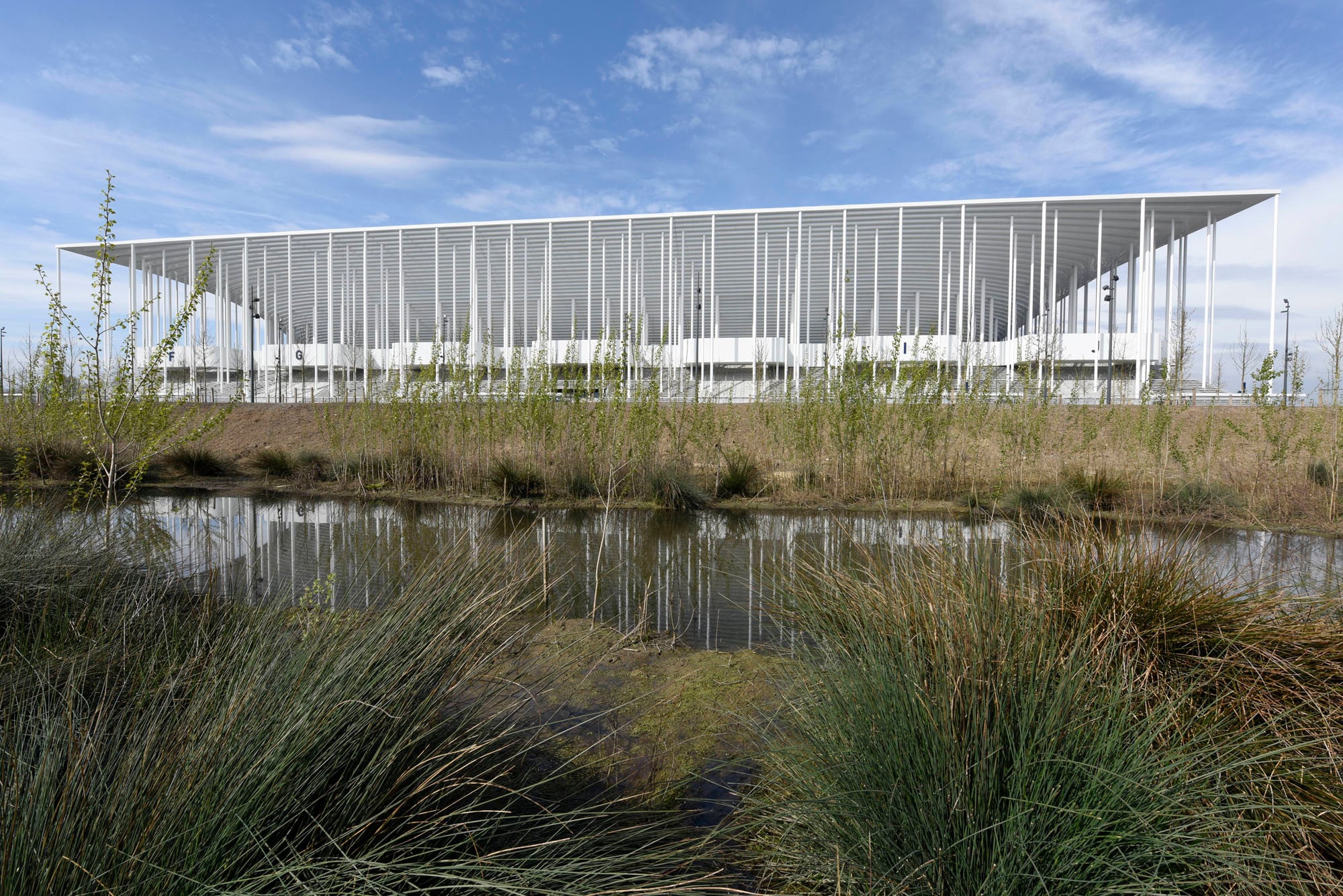 Die aus dem Zentrum empor schwingende, weit auskragende Tribünen- und Dachkonstruktion basiert auf einem Entwuf der Basler Architekten Herzog und de Meuron