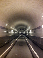Blick in den Alten Elbtunnel; im Zuge seiner Sanierung wurden die weißen Fliesen entfernt, dahinter fand sich viel Korrosion an der Tunnelstahlkonstruktion
