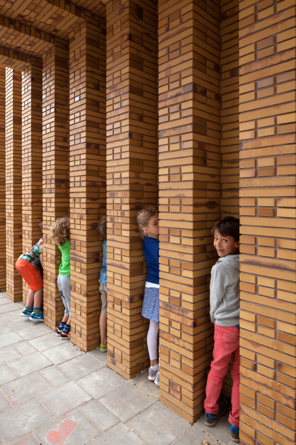 Die Zwischenräume in der Fassade werden von den Schülern gerne in die Spiele einbezogen