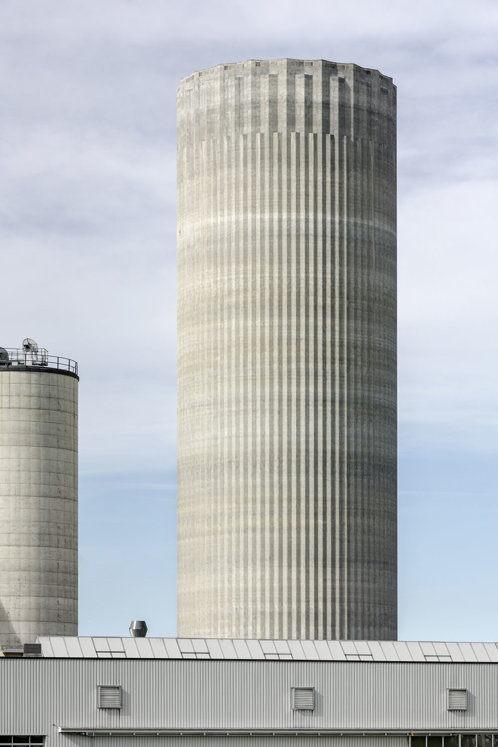 Wie die Kanneluren einer klassischen Säule legen sich Zacken um das Pelletsilo