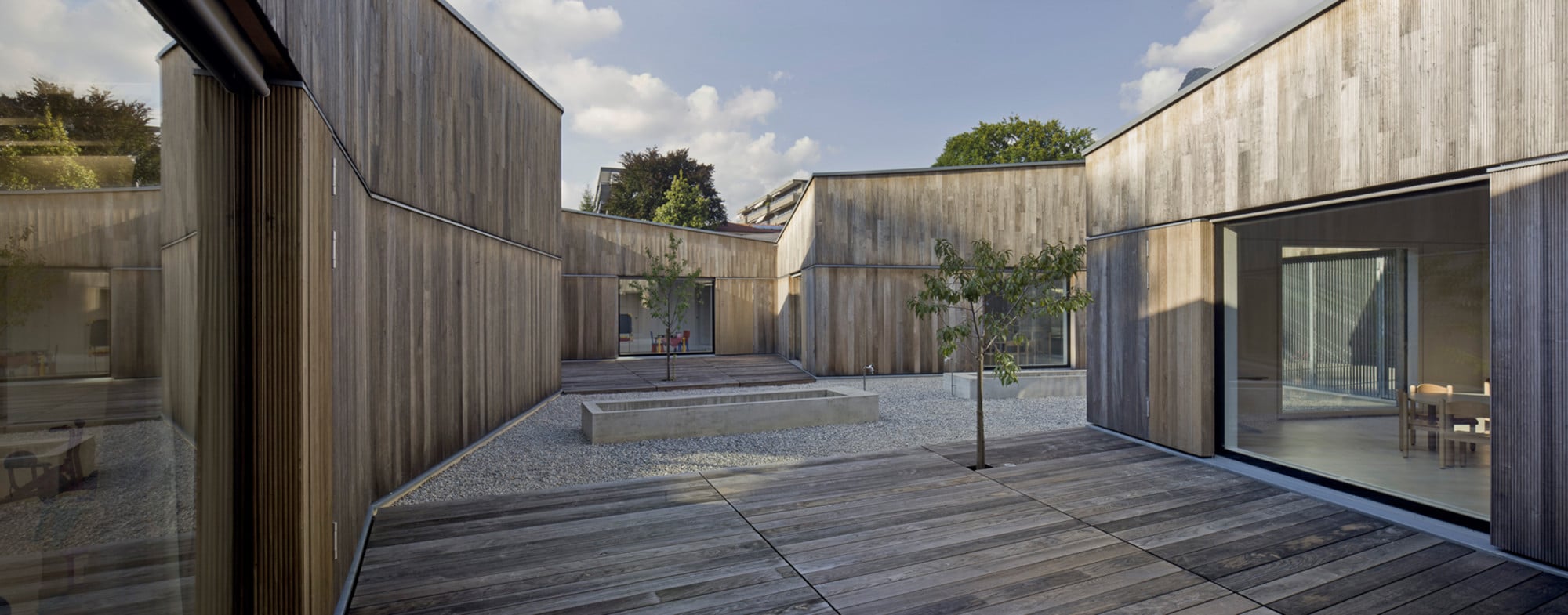 Das Gebäude beherbergt fünf Kindergartengruppen, jeder Gruppe ist ein eigener kleiner Gartenhof mit Obstbaum zugeordnet