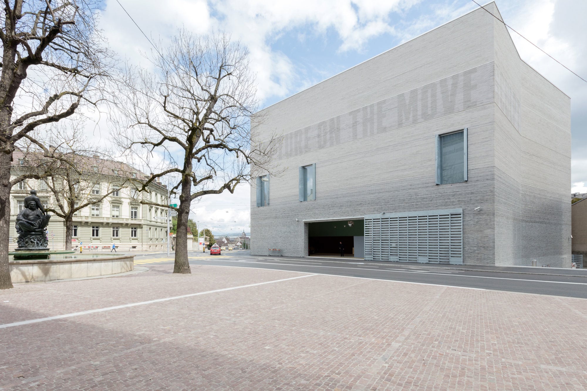 Nur wenige Öffnungen sind in die Fassade aus hellgrauen Ziegeln eingeschnitten (Südwestansicht)