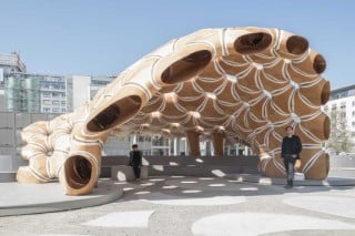 Auf dem Campus der Universität Stuttgart schwingt sich der Pavillon zu einer halb offenen Überdachung auf