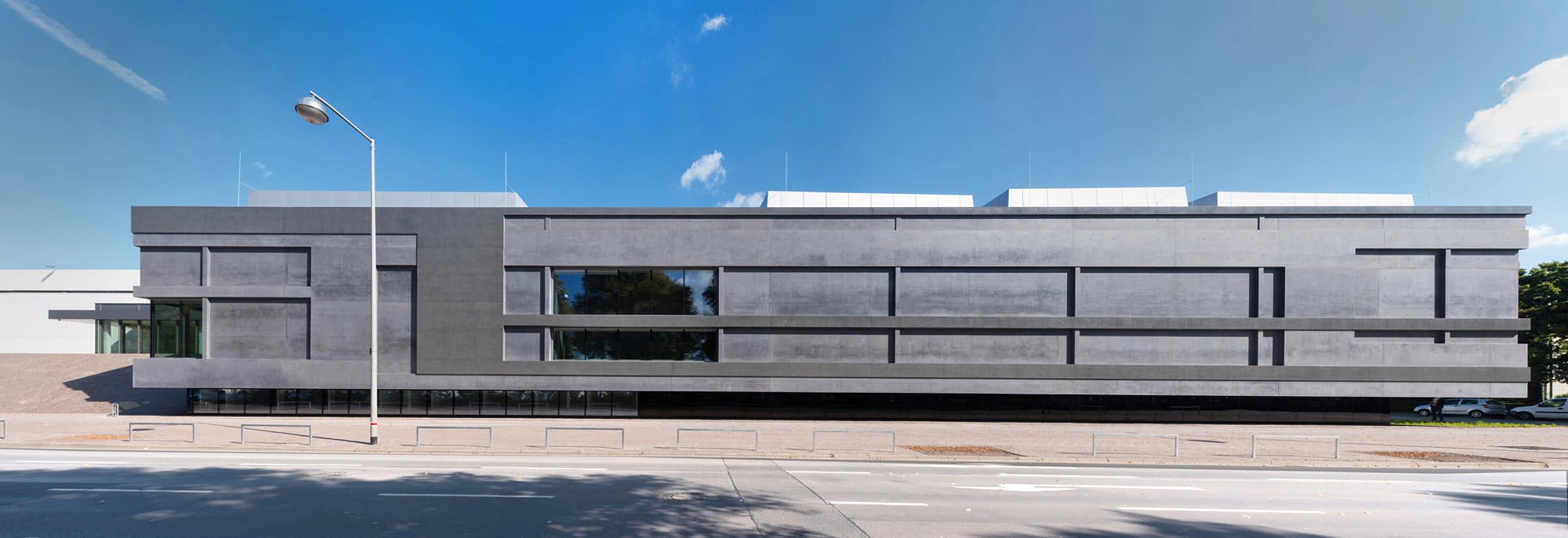Wie behauener dunkler Stein wirkt die Sichtbetonfassade des Erweiterungsbaus, hier die Südwestansicht