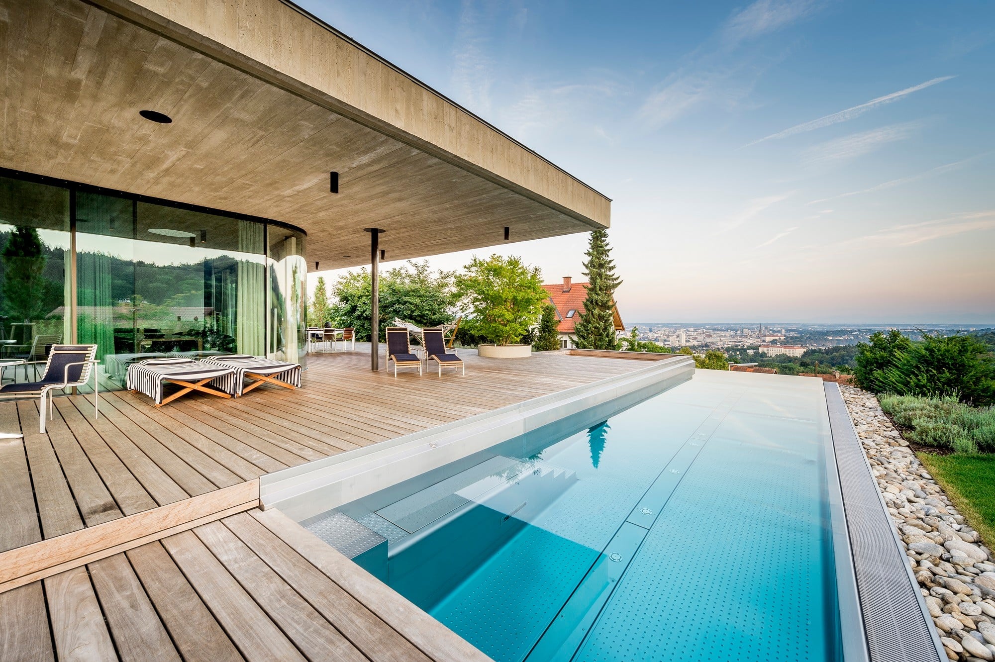 Sowohl der rundum verglaste Wohnraum als auch Terrasse und Pool bieten Aussicht über die Stadt