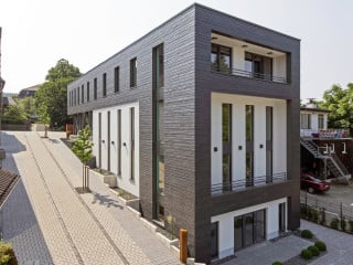 Das Foyer mit Ausrichtung zur Kaiserstraße und seitlichen Klostergasse hin ist durch Stahlstützen gefasst – eine Reminiszenz an den Vorgänger aus Fachwerk (Ostansicht)