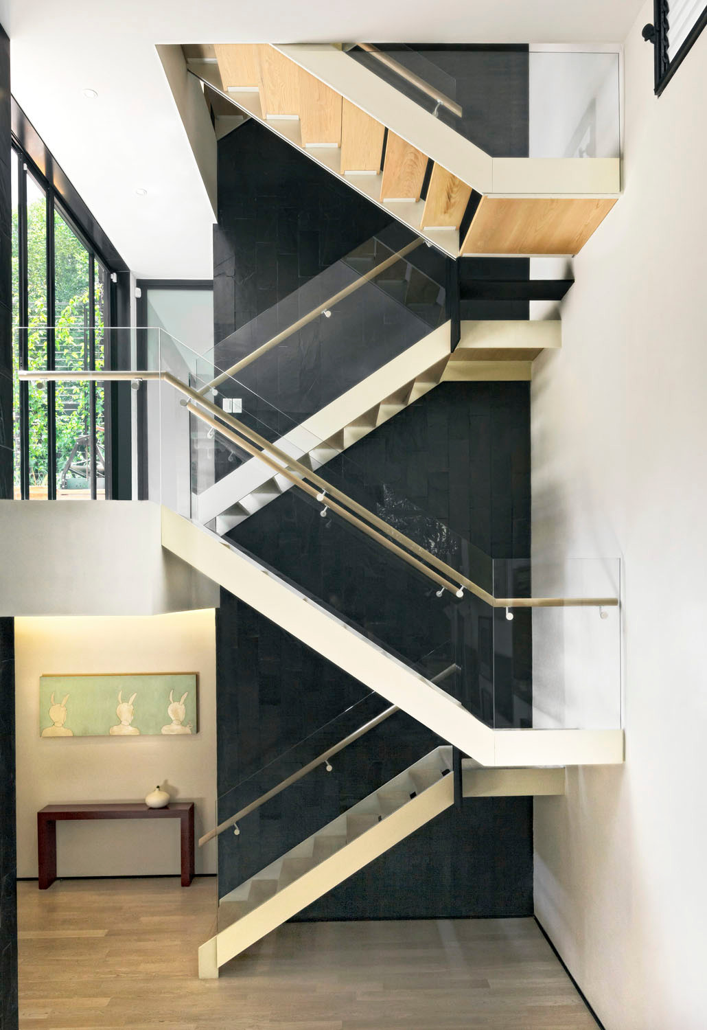 Teil des Wohnraums ist eine skulpturale zweiläufige Treppe aus Stahl, Glas und Holz
