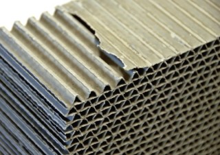 Für die Herstellung des Verbundwerkstoffs Ecocell werden Wabenplatten aus Wellkarton mit Zement beschichtet