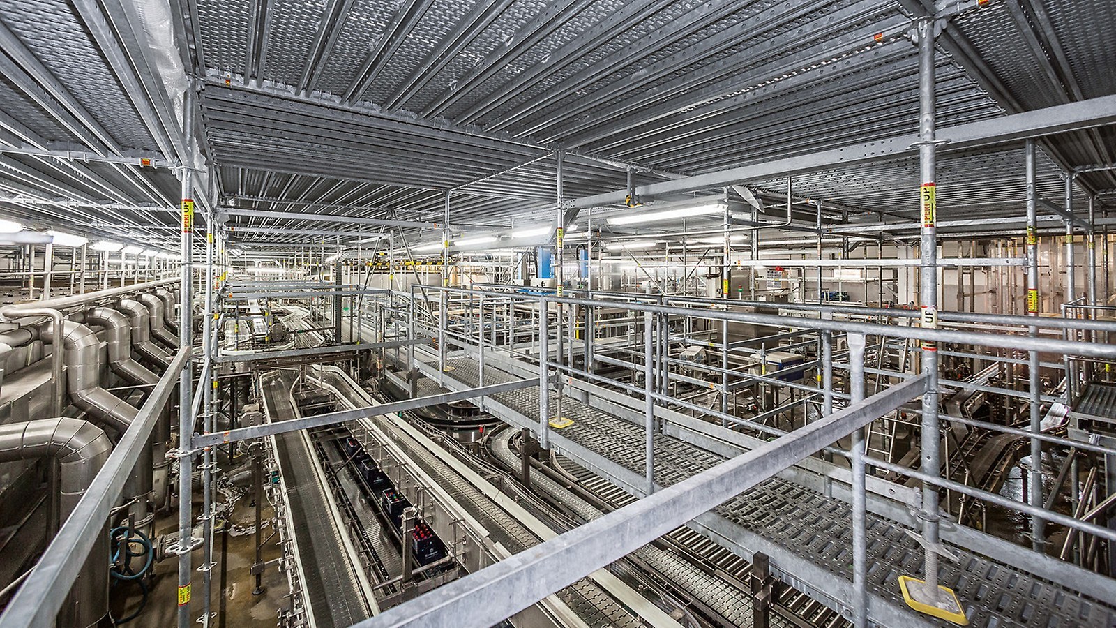 Ein Schutzgerüst ermöglicht die nahezu ungestörte Aufrechterhaltung der Produktion während umfangreicher Modernisierungsmaßnahmen an der Dachkonstruktion einer Fabrik