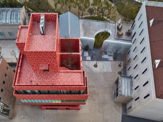 Das Ya Chang Art Center ist markanter Mittelpunkt eines ehemaligen Fabrikgeländes; für die Fliesenfassade entwarf der Künstler Ding Yi Muster, die an Kreuzstich-Stickereien erinnern (Ostansicht)