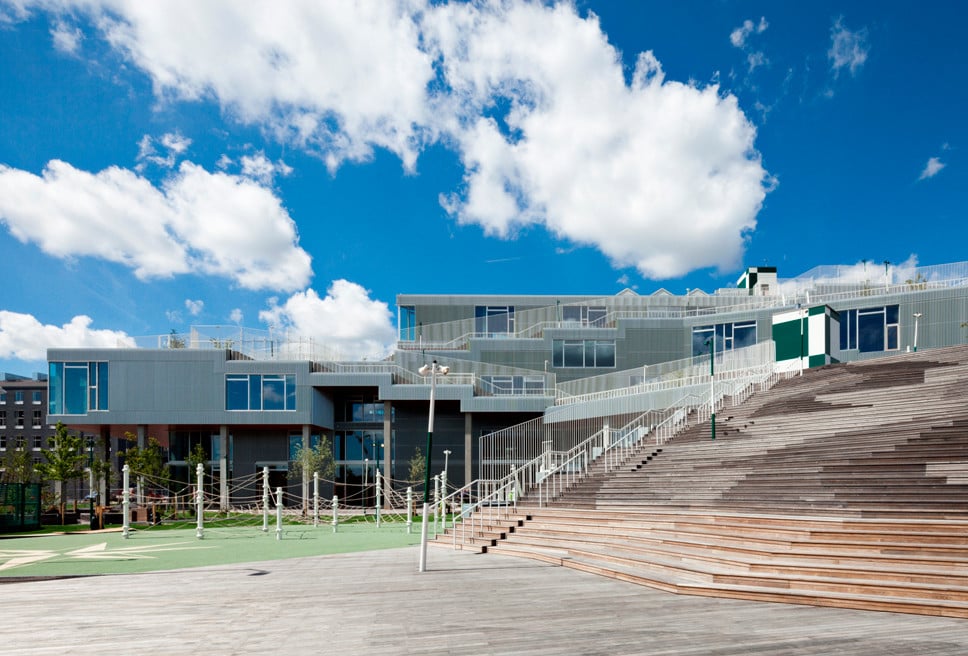 Die hinterlüftete Fassade der Schule wird aus mineralischen Fassadentafeln und Lamellen aus recyceltem Aluminium gebildet