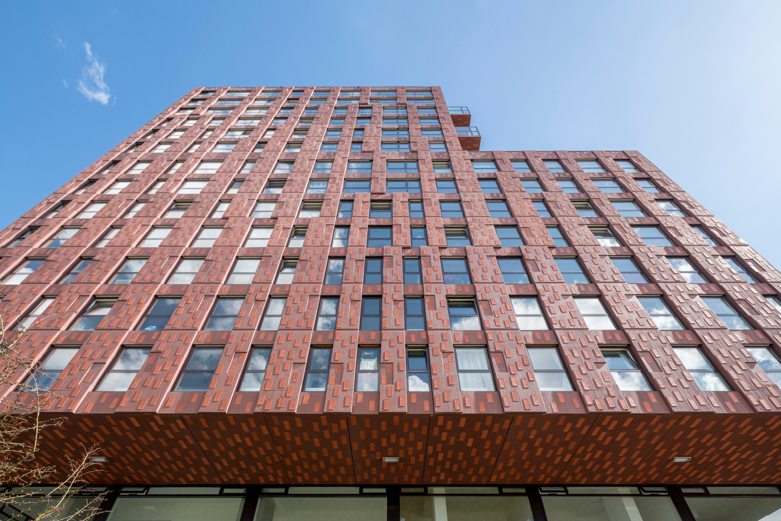 Vertikale Fensterformate und die Hochkantfliesen lassen die Fassade optisch emporstreben
