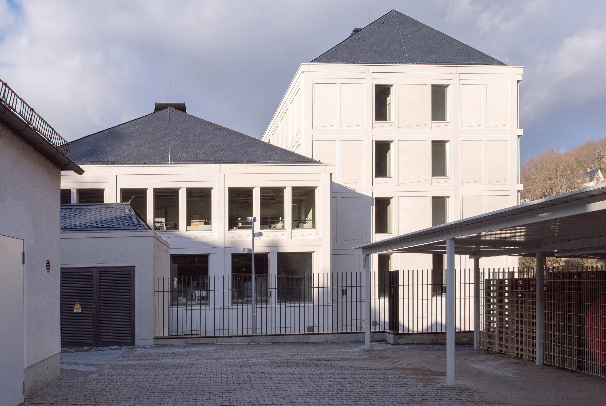 Beide Neubauten verfügen über schiefergedeckte Walmdächer und Fassaden aus sandgestrahlten Betonfertigteilen (Südansicht)