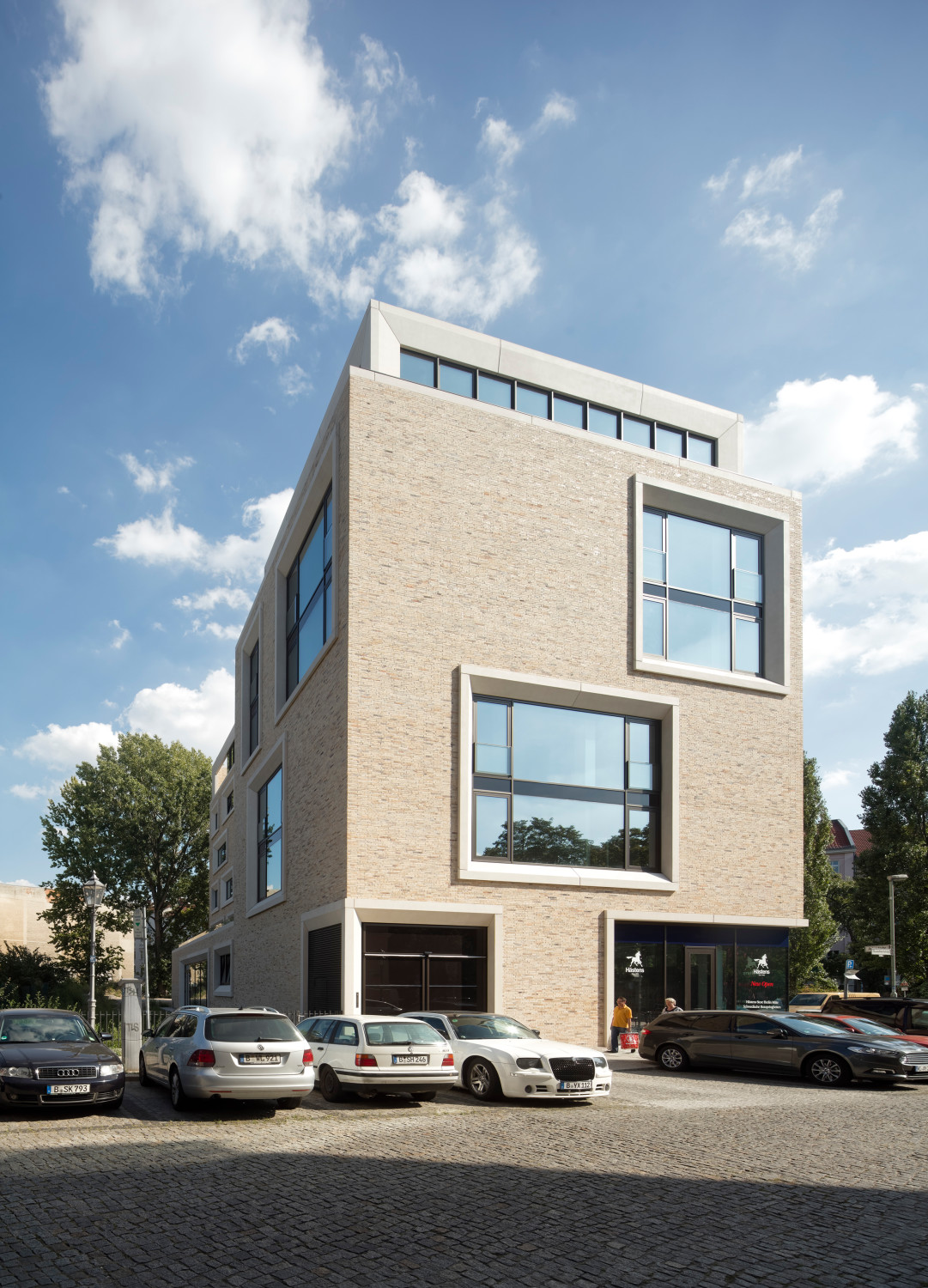 Die großen Fensterflächen unterschiedlichen Formats sind mit weißen Betonfertigteilen eingefasst