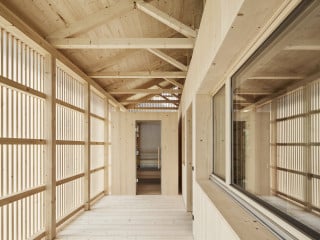 Im Bregenzerwald beherbergt das Ferienhaus Islen hinter einer modernen, hellen Fichtenholzfassade Urlaubsgäste (Westansicht)